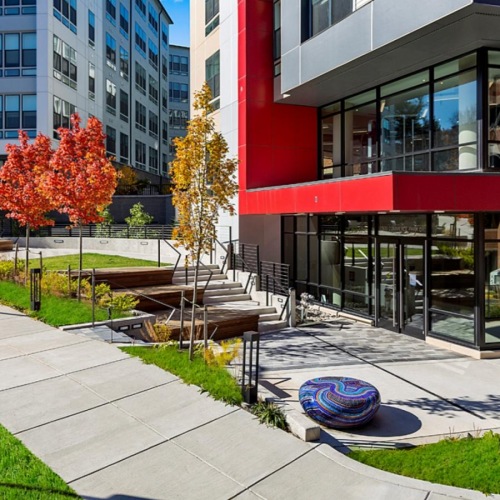 a courtyard with trees and benches in front of building